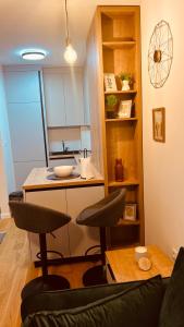 a kitchen with two stools in a living room at Ski INN apartment Jahorina in Jahorina