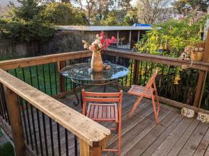 a table with chairs and a vase with flowers on a deck at Relax in unpretentious peaceful and authentic house with public transportation cafes and U of Berkeley close by in Albany