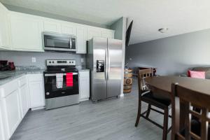 a kitchen with a stainless steel refrigerator and a table at IU Soccer HIdeaway in Bloomington