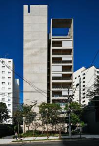 un edificio blanco alto frente a algunos edificios en Huma Klabin, en São Paulo