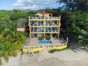 an aerial view of a yellow building on the beach at Del Playa #4 Condo in West End