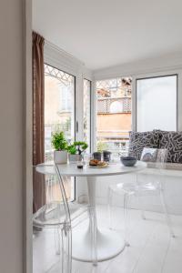 a white dining room with a white table and chairs at Vittoria apartment BDB in Rome