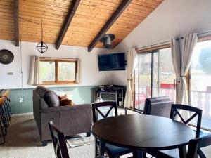 ein Wohnzimmer mit einem Tisch und einem Sofa in der Unterkunft White Mountain Escape - Ski Attitash in Bartlett