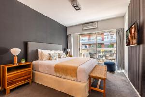 een slaapkamer met een bed en een groot raam bij Family Apartment with Puente de la Mujer View in Puerto Madero in Buenos Aires