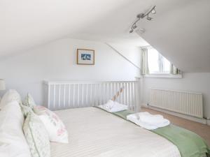 a white bed in a room with a window at Nutwood in Charmouth