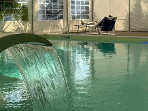 a person sitting in a chair next to a swimming pool at Agriturismo L'impero Romano in Gerace