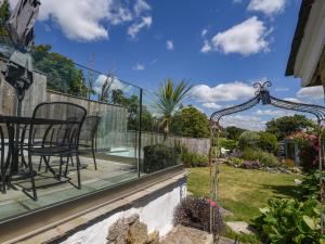 a patio with a table and chairs on a balcony at Nutwood in Charmouth