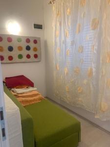 a small bedroom with a green bed and a painting at Apartment Art Adriatic in Punat