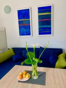 a living room with a blue couch and a table with a vase at Apartment Art Adriatic in Punat