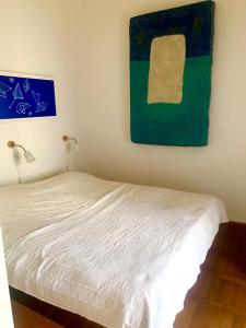 普纳特Apartment Art Adriatic的卧室里有一张床，墙上挂着一幅画