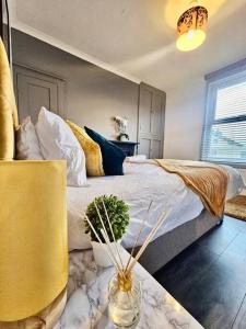 een slaapkamer met een groot bed en een gele stoel bij 4 bedroom Hse close to Riverside in Gravesend