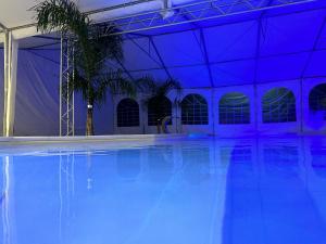 an empty swimming pool with blue lights in a building at Agriturismo L'impero Romano in Gerace