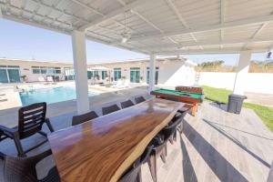 un patio con mesa de ping pong y piscina en Chalet full equipado - La Arenosa 