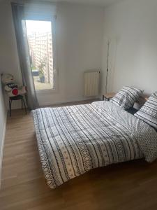 een slaapkamer met een bed en een raam bij Appartement cosy en plein centre-ville in Évry-les-Châteaux