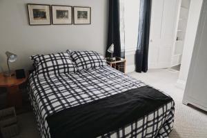 a bedroom with a bed with a black and white blanket at The Trafalgar in Oakville