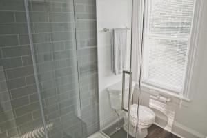 a bathroom with a toilet and a glass shower at The Trafalgar in Oakville