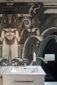 a bathroom with a sink and a tile wall at Vittoria apartment BDB in Rome