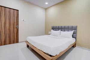 a bedroom with a bed and a wooden door at OYO Hotel 7 Star in Surat