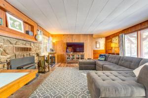 a living room with a couch and a stone fireplace at Charming Idaho Springs Retreat on Chicago Creek! in Idaho Springs