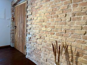 a brick wall with a wooden door in a room at BERGLIEBE - Wunderschöne Wohnung in Kempten - Stadtmitte in Kempten +5 photos