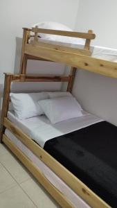 a wooden bunk bed with white pillows on it at COMODO APARTAMENTO AMOBLADO con piscina fuera del alojamiento a 1 K m in San Gil