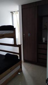 a room with two bunk beds and a door at COMODO APARTAMENTO AMOBLADO con piscina fuera del alojamiento a 1 K m in San Gil