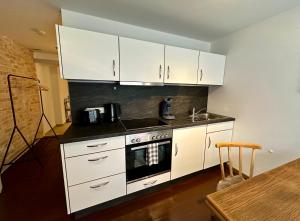 a kitchen with white cabinets and a stove at BERGLIEBE - Wunderschöne Wohnung in Kempten - Stadtmitte in Kempten
