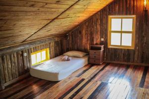 a bedroom with a bed in a wooden cabin at Chalé Sol da Montanha em Termas do Gravatal - SC in Gravatal