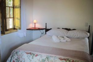 a bedroom with a bed with towels on it at Chalé Sol da Montanha em Termas do Gravatal - SC in Gravatal