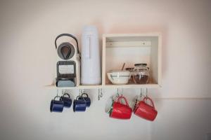 a shelf with a bunch of kitchen items on it at Chalé Sol da Montanha em Termas do Gravatal - SC in Gravatal