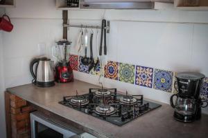 a stove top oven in a kitchen with tiles on the wall at Chalé Sol da Montanha em Termas do Gravatal - SC in Gravatal
