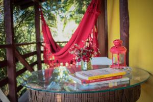a glass table with books and a lamp on it at Chalé Sol da Montanha em Termas do Gravatal - SC in Gravatal