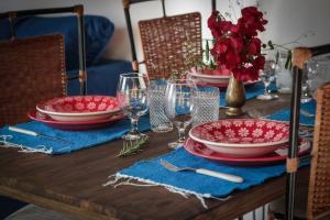 a table with red plates and wine glasses on it at Chalé Sol da Montanha em Termas do Gravatal - SC in Gravatal