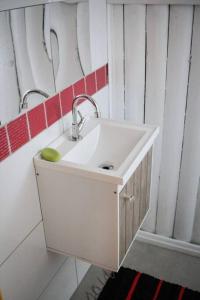 uma casa de banho com um lavatório branco e um espelho. em Chalé Sol da Montanha em Termas do Gravatal - SC em Gravatal