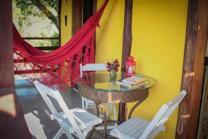 a table and chairs in a room with a yellow wall at Chalé Sol da Montanha em Termas do Gravatal - SC in Gravatal