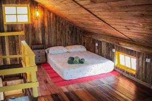 um quarto com uma cama num chalé de madeira em Chalé Sol da Montanha em Termas do Gravatal - SC em Gravatal