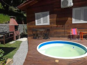 a hot tub on a deck next to a house at Chalé Sol da Montanha em Termas do Gravatal - SC in Gravatal