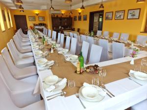a long dining room with white tables and white chairs at Pri štorklji in Moravske-Toplice