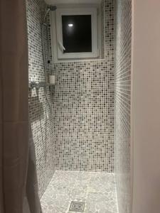 a bathroom with a shower with a television in it at Chez Joseph in Mauléon