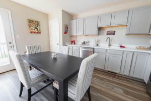 a kitchen with a black table and white cabinets at Bobby Knight Hall in Bloomington