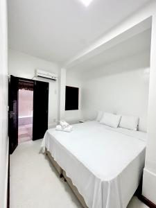 a white bedroom with a large white bed in it at Pousada VIGLAMO JERI in Jericoacoara