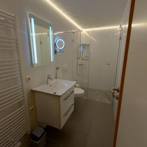 een witte badkamer met een wastafel en een toilet bij FeWo-Lieck in Heinsberg