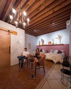 a man and a woman sitting in chairs in a room at CASA DAMIANA in Lagos de Moreno