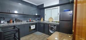 a kitchen with a refrigerator and a washer and dryer at Maison Mamdy Triplex & Rooftop in Marrakesh +41 photos