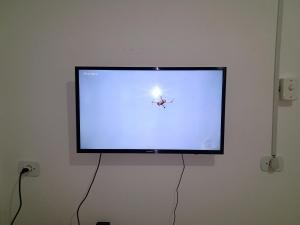 a flat screen tv hanging on a wall at Pousada chácara amarela - Analandia SP in Analândia
