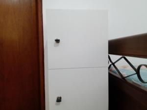 Pousada chácara amarela - Analandia SP في أنالانديا: خزانة بيضاء في غرفة النوم مع سرير