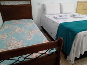 Habitación con 2 camas individuales y manta verde. en Pousada chácara amarela - Analandia SP, en Analândia