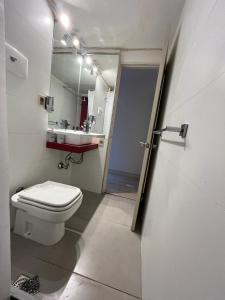 y baño con aseo blanco y lavamanos. en Apartamento en POCITOS vista al mar en Montevideo