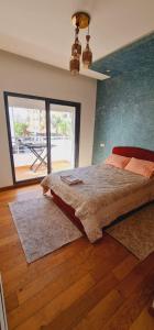 a bedroom with a large bed and a large window at Jnane Californie in Casablanca