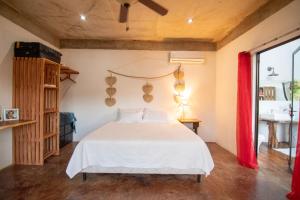 a bedroom with a white bed with a red curtain at Marbella Retreats Casa Roja in Santa Cruz